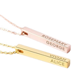 Two gold bar necklaces with engraved names on a white background